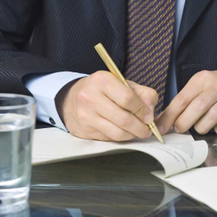 man writing on a document