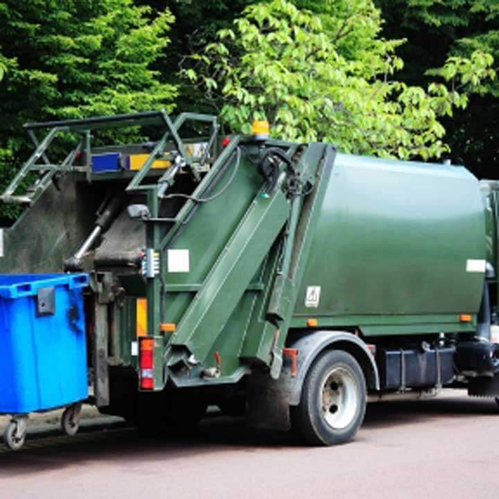 Green waste services truck with blue bins