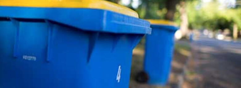 blue plastic wheelie bin with a yellow lid