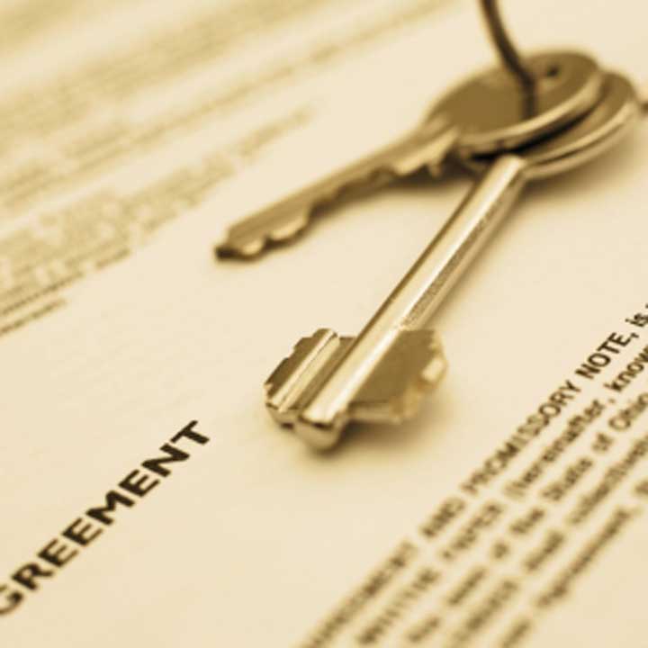 The word 'agreement' on a piece of paper with a bunch of keys on top