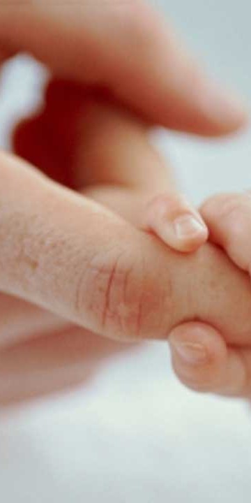Baby holding an adults finger