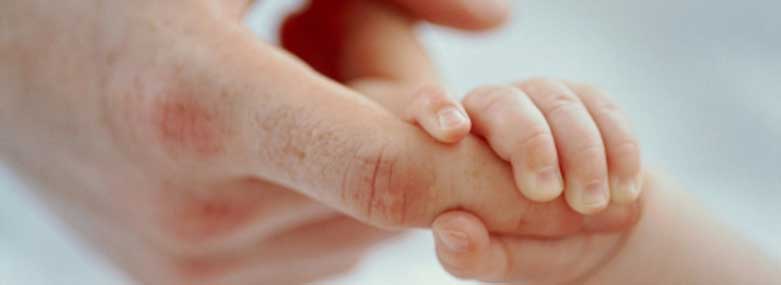 Baby holding an adults finger