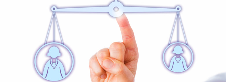 Index finger of a white collar manager touching a virtual pair of scales to balance out a big female knowledge worker icon versus an identical, yet smaller female office worker symbol. Close up.