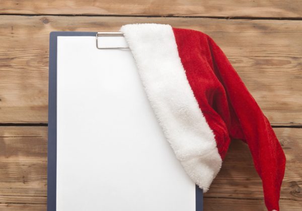 Santa hat on clipboard with blank paper sheet for your text