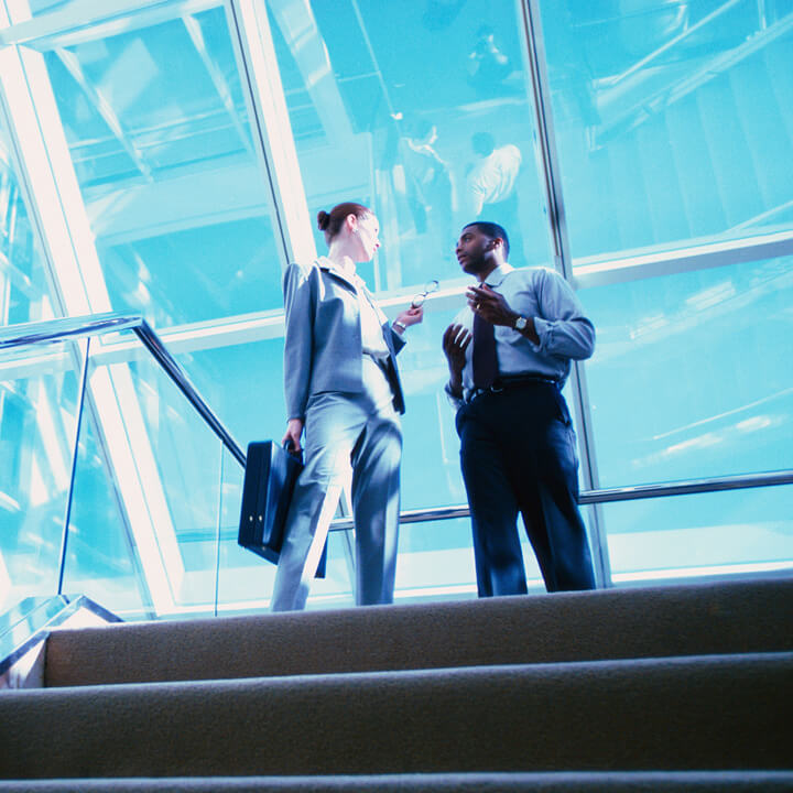 Colleagues talking at the top of a staircase