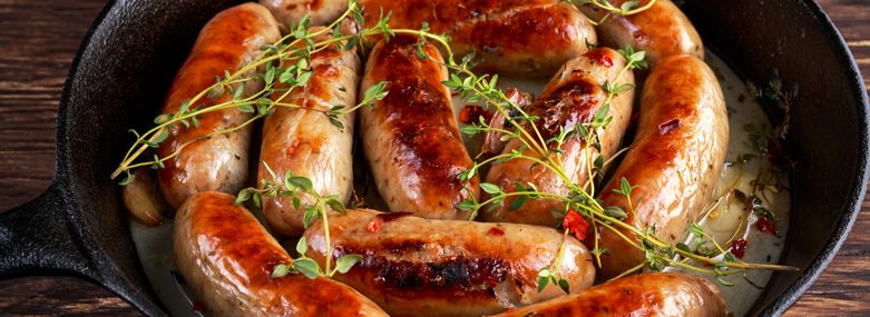 Home-made Pork Sausages in rustic pan with thyme