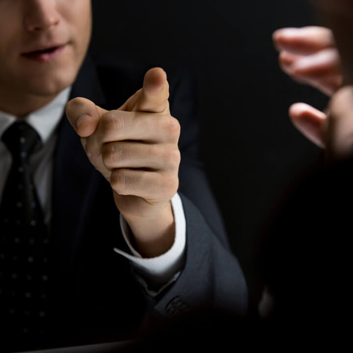 Angry official pointing hand to suspect and asking questions