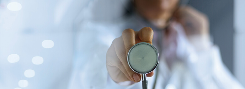 Doctor with a stethoscope in the hands on hospital background