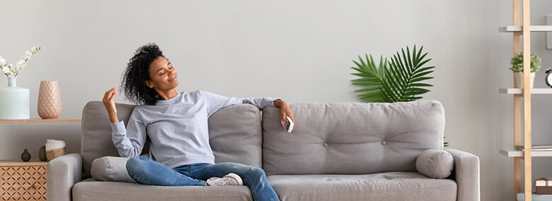 Woman sitting on comfortable couch in living room at modern home