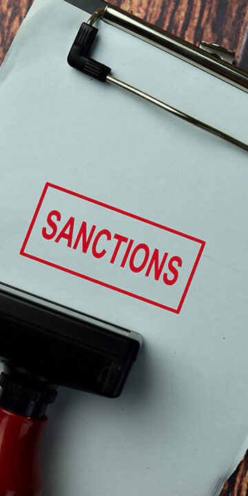 Close-up-Red-Handle-Rubber-Stamper-and-text-Sanctions-isolated-on-White-Background