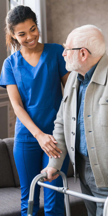 a nurse, benefiting from the health and care worker visa, helping old elderly disable man 720 x 720