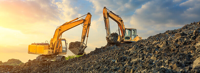 wo-excavators-work-on-construction-site-at-sunset