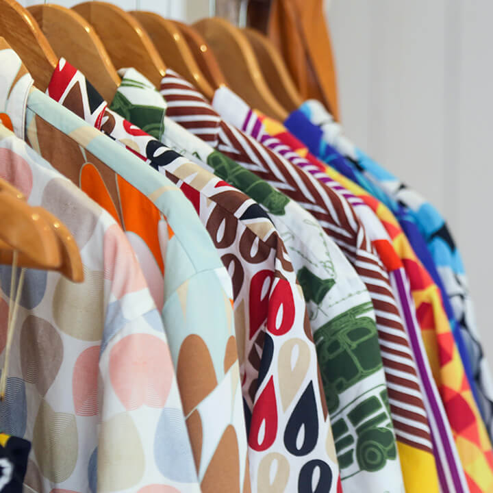 Variety-of-colorful-shirts-hanging-on-the-wooden-hangers-close-up