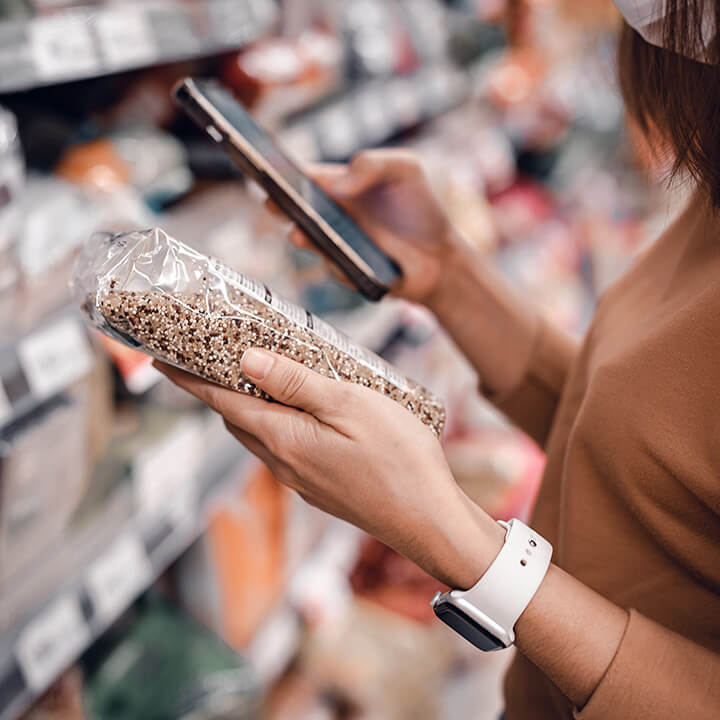 Woman-shopping-in-supermarket-and-reading-product-information.-Costumer-buying-food-at-the-market