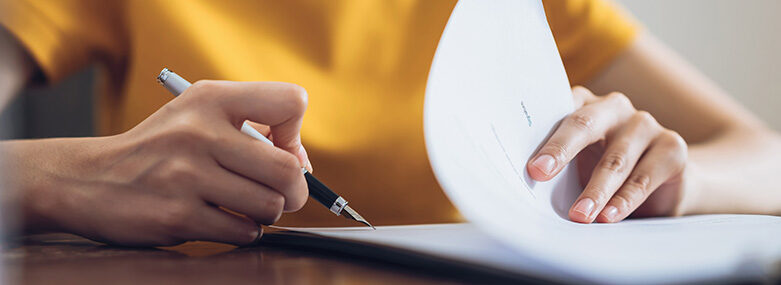 Woman-signing-document-and-hand-holding-pen-putting-signature-at-paper-order-to-authorize-their-rights