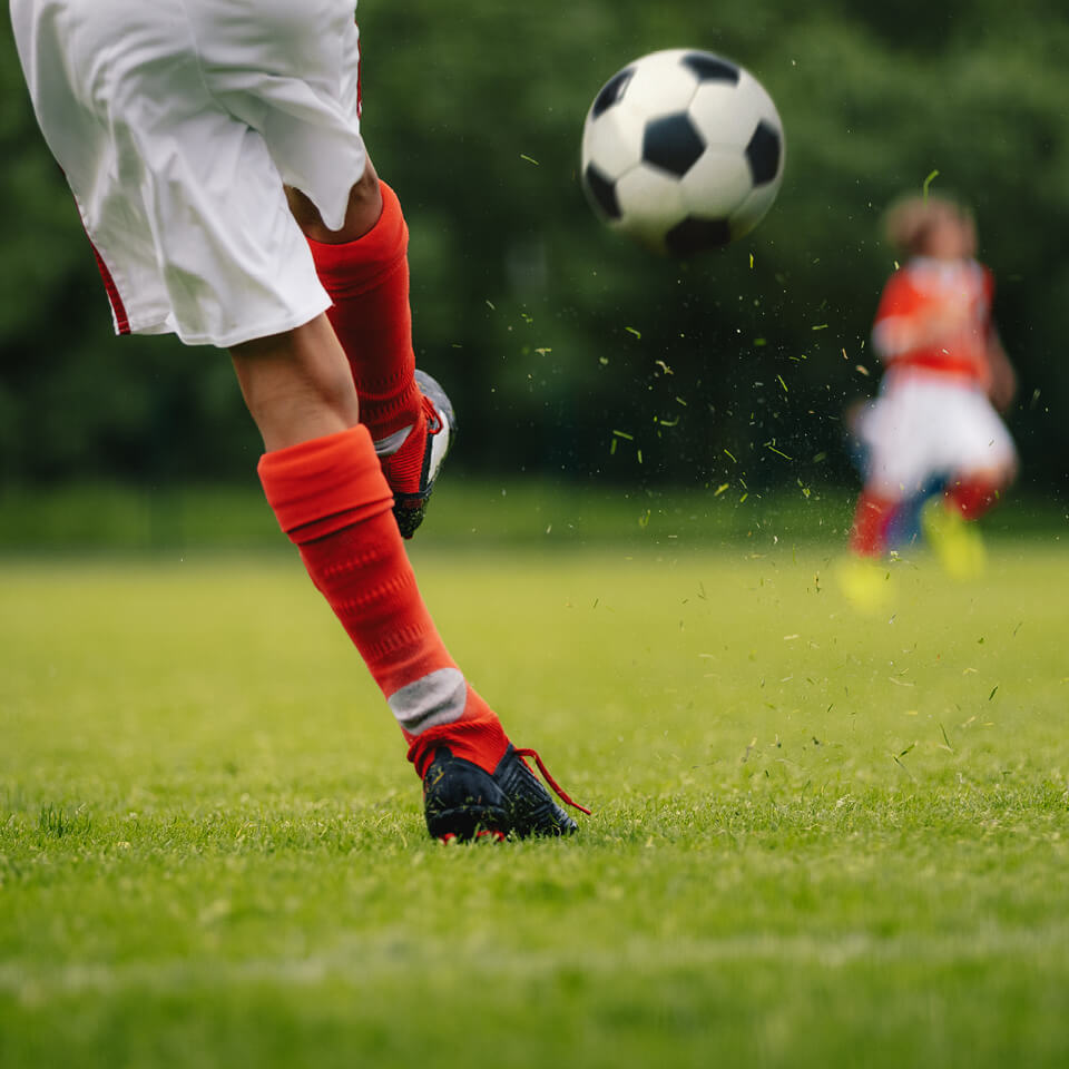 Man kicking a football on a field