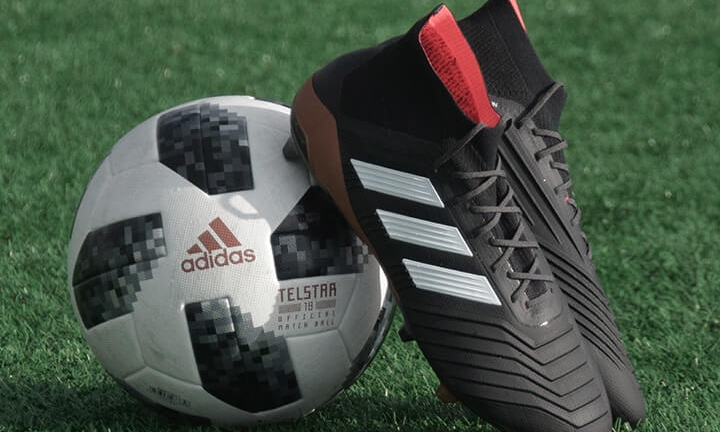black-football-boots-resting-on-football-