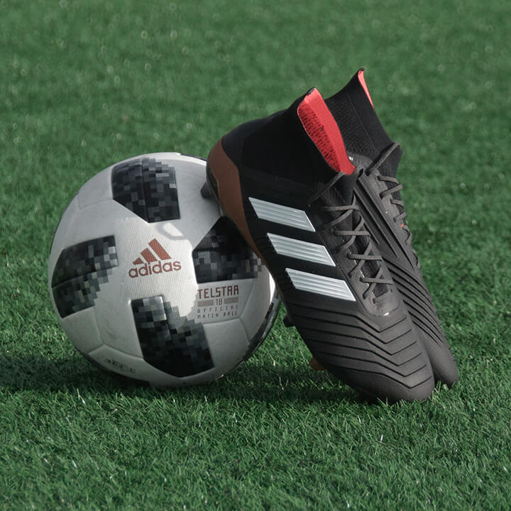 black-football-boots-resting-on-football-