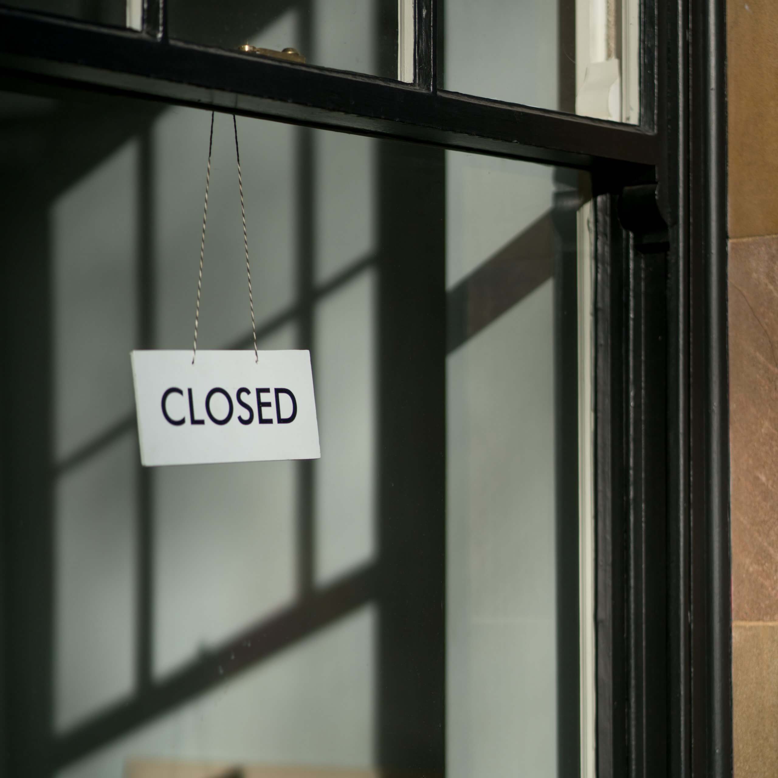 Closed sign on shop window - a visual metaphor for the topic of this article, business interruption insurance