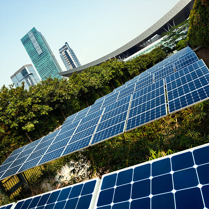An image of a set of solar panels at a diagonal angle, with a building in the background. A visual metaphor for this post on ESG and environmental reporting.