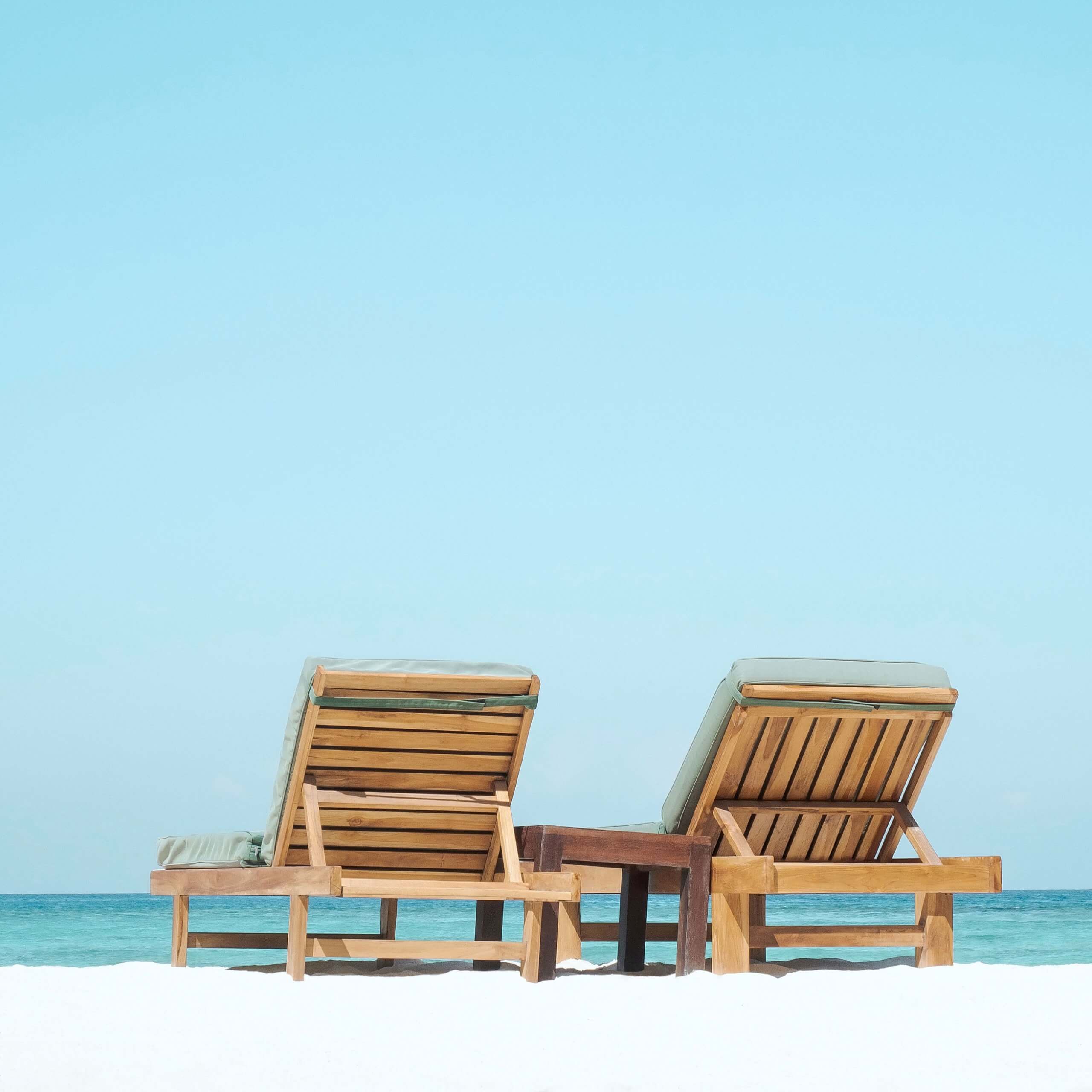 An image of two deck chairs on a beach. A visual metaphor for the topic of this article, Holiday Pay.