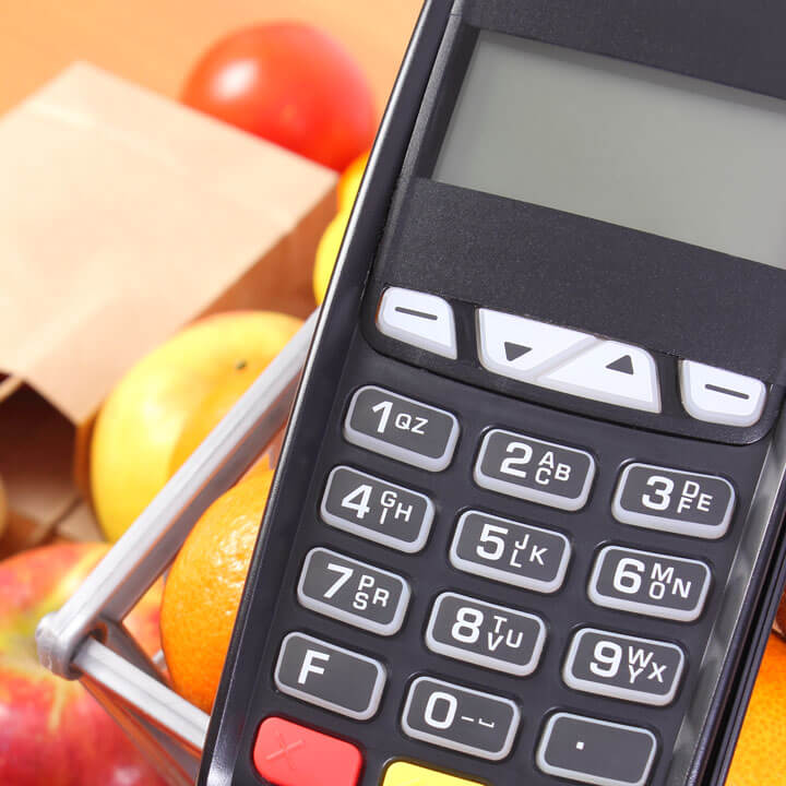 An image of a calculator, with a background of vegetables. A metaphor for the topic of this article, Alternative finance in the Food & Drink sector.