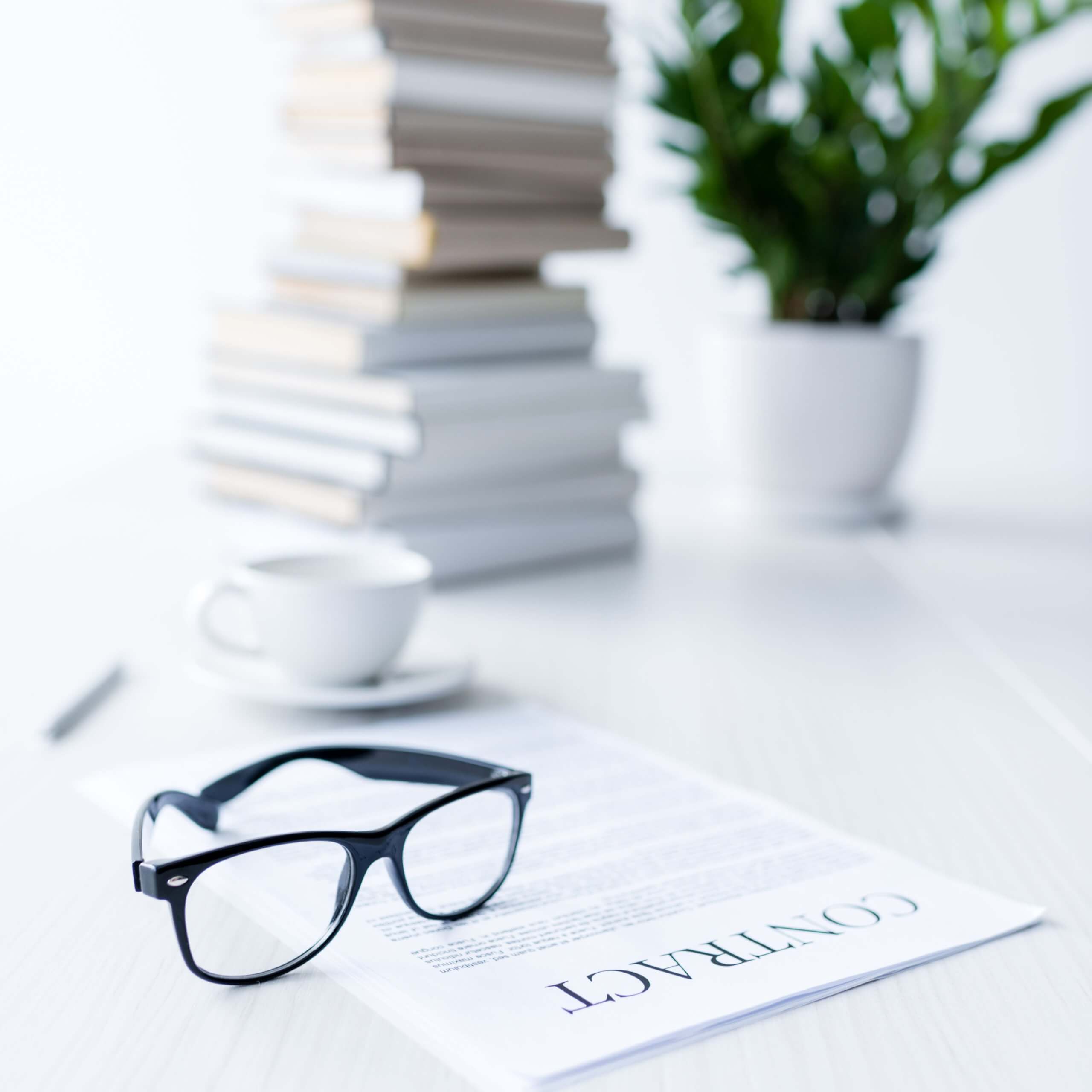 An image of a set of glasses on a table, a stack of books and a plan behind. A visual metaphor for the topic of this post: Labour's employment reform pledges.