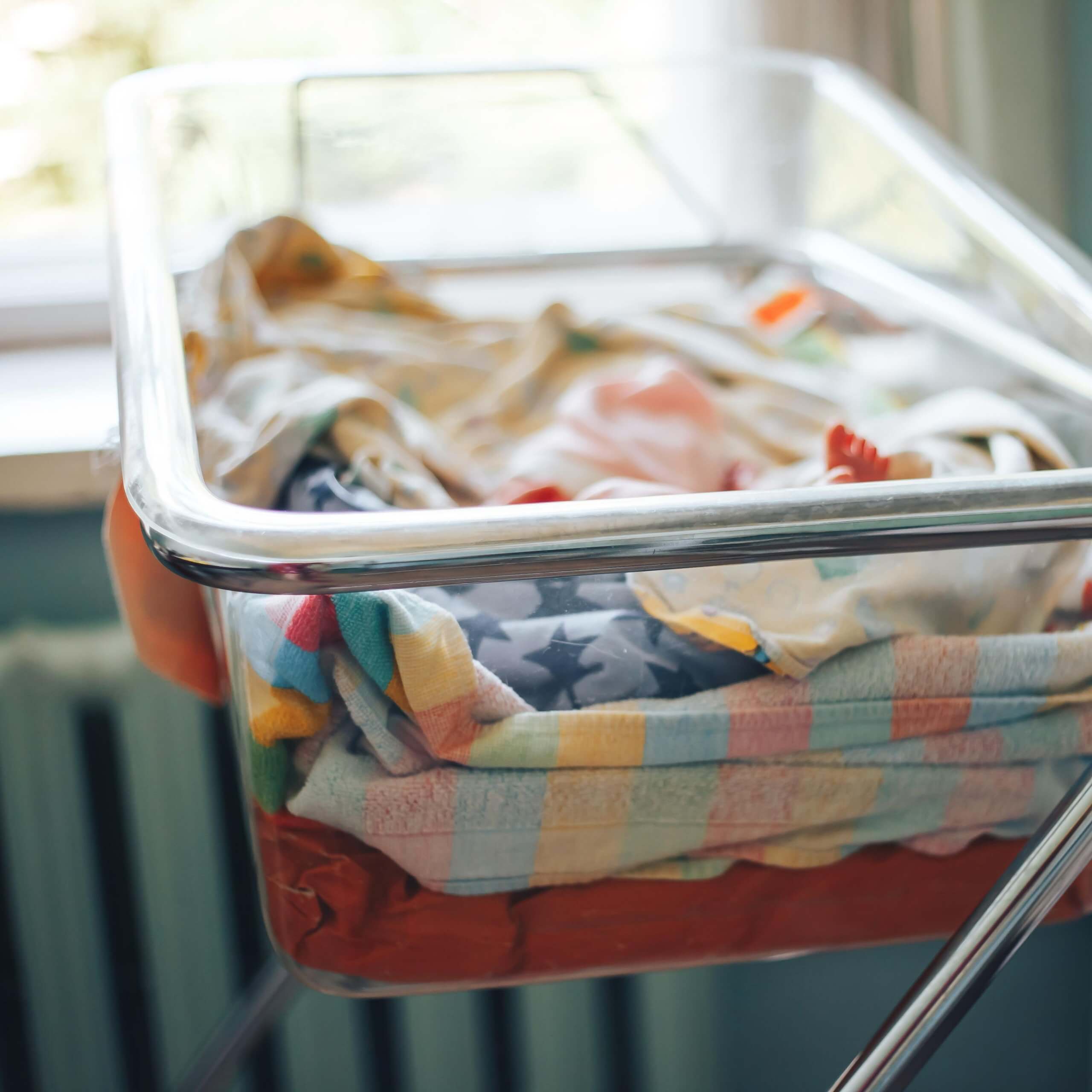 An image of an empty cot, with light coming in from a nearby window. A visual metaphor for the topic of this article, The Neonatal Care (Leave and Pay) Act 2023.
