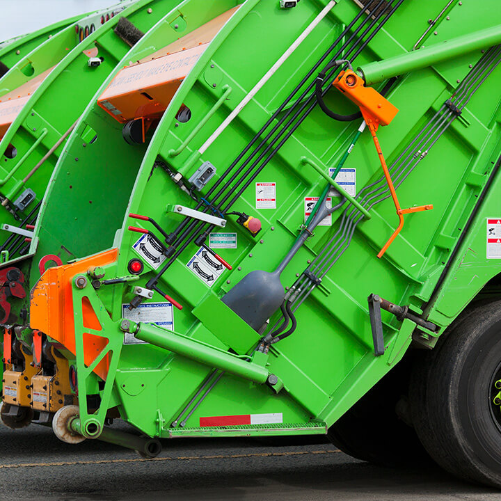 An image of severalwaste trucks back to back - a visual metaphor for the thopic of this piece, compliance assessment report and the implications of the Suez case against the EA