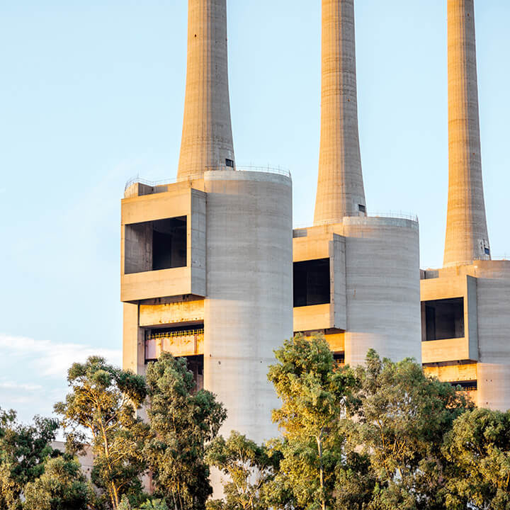 An image of three chimneys at an industrial plant, a visual metaphor for the topic of this piece; Energy sector commission claims: Legal and practical insights