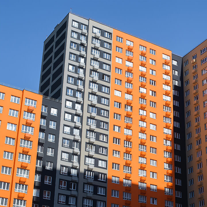 An image of a block of flats, half orange and half grey cladded, a visual metaphor for the topic of this piece, Building Safety Gateway 2 applications.