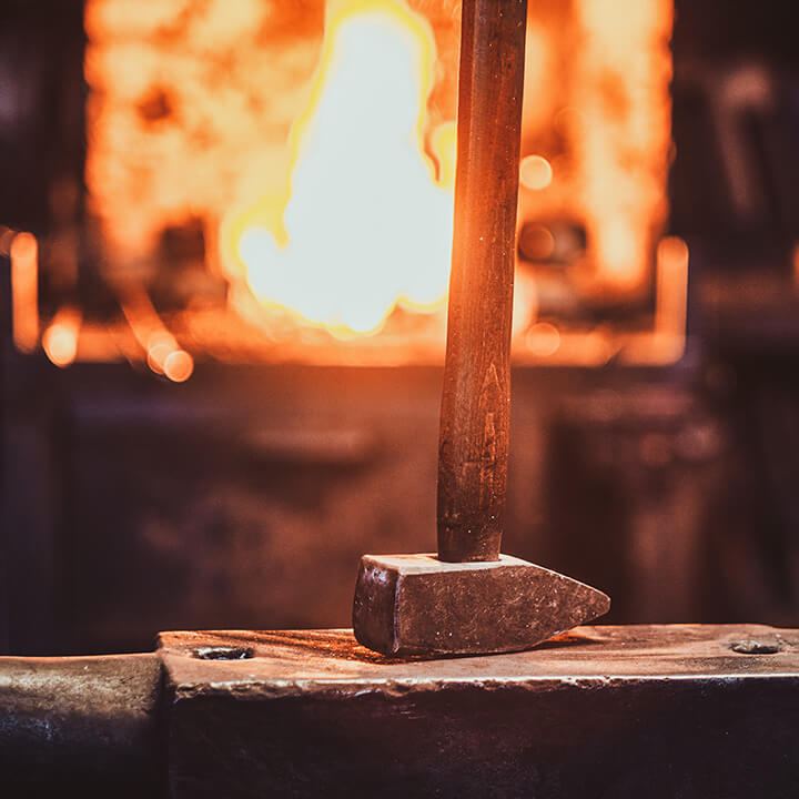 An image of a sledgehammer in front of a forge, a visual metaphor for the topic of this article, the Walker Morris Forge initiative